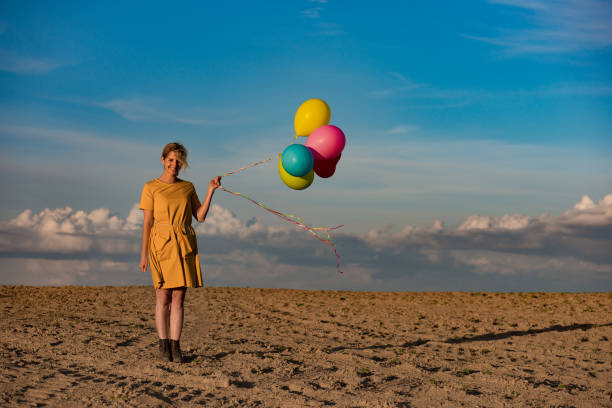 istock woman with colourful balloons on seaside 680862648
