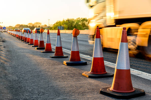 Evening view UK Motorway Services Roadworks Cones Evening view UK Motorway Services Roadworks Cones. road construction photos stock pictures, royalty-free photos & images