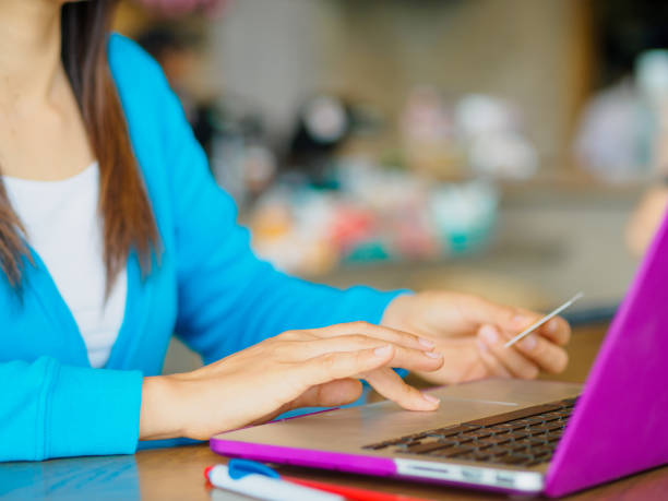 istock Pretty Young womans hands holding a credit card and using laptop computer for online shopping. 680864996