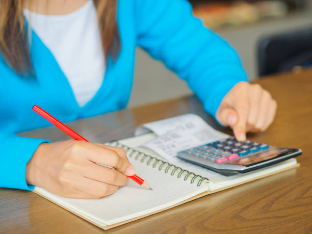 istock woman working with calculator, business document and laptop computer notebook 680865134