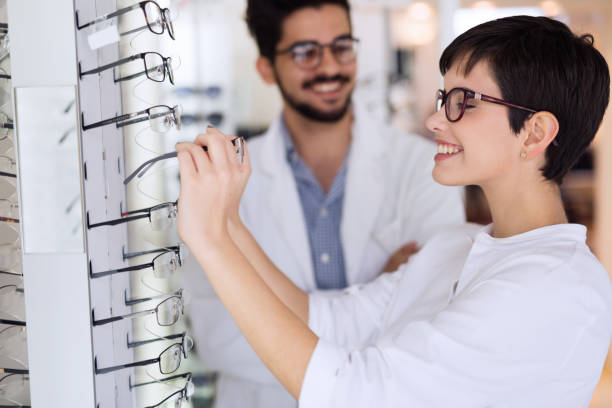 istock Beautiful woman with optician trying eyeglasses 680873982