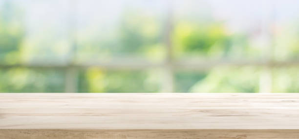 istock Wood table top on blur green garden from window view. 680874412