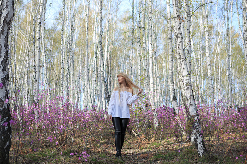 outdoor portrait of a beautiful middle aged blonde woman. attractive sexy girl in a field with flowers