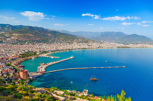 Landscape with marina and Kizil Kule tower in Alanya peninsula, Antalya district, Turkey, Asia. Famous tourist destination with high mountains. Summer bright day