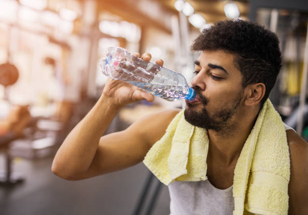 istock Thirsty African American man drinking water in a gym. 680885984
