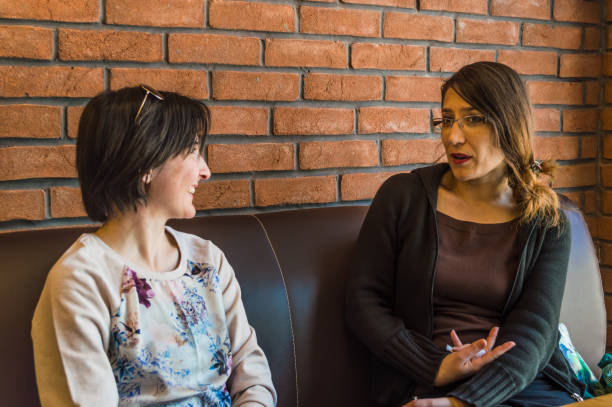 istock Two brunette young women sitting in a cafe having conversation 680888264