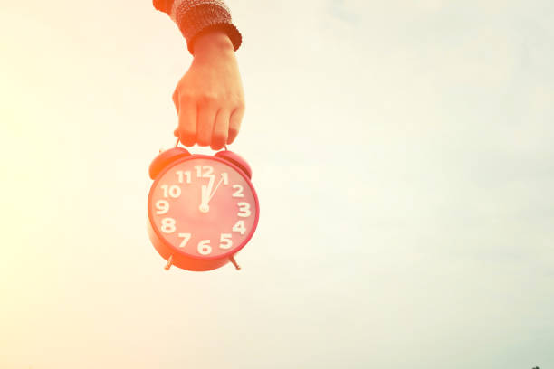 istock hands holding an red alarm clock, time concept 680889630