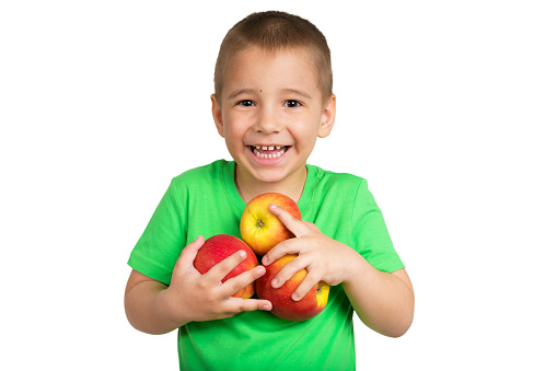 Portrait of a happy child with apples in hands on a white background