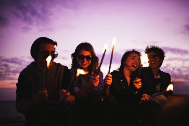 istock Hipsters laughing and having fun with sparklers at sunset 680926740
