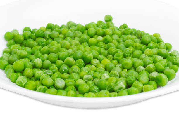 istock Blanched green peas in white dish closeup 680947136
