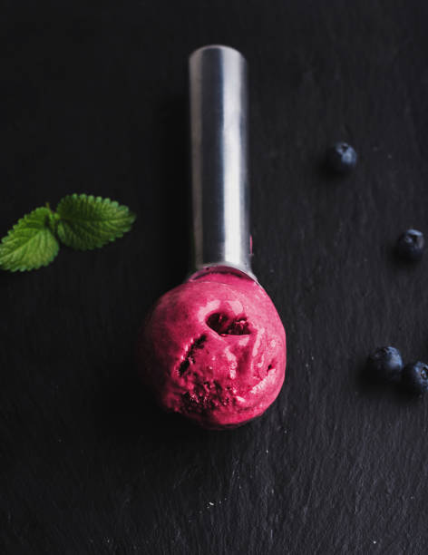 istock Blueberry ice-cream scoop over black slate stone background 680955348