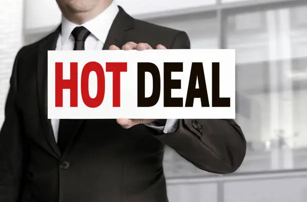 Hot Deal sign is held by businessman concept.