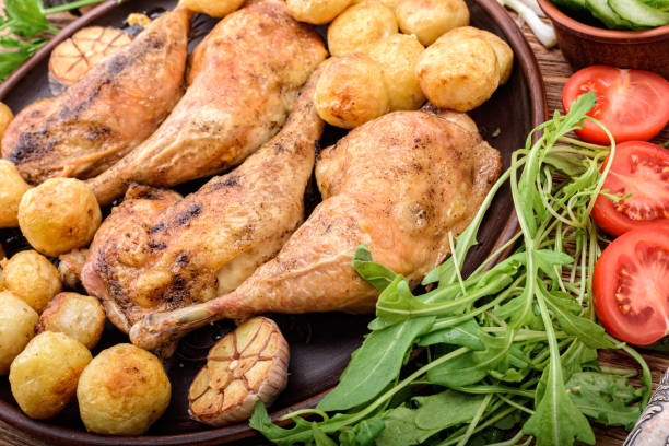 istock Chicken legs with baked potatoes and vegetables . 680983034