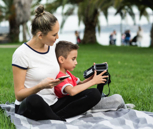 istock Mother and son testing Virtual Reality simulator on the street 680998292