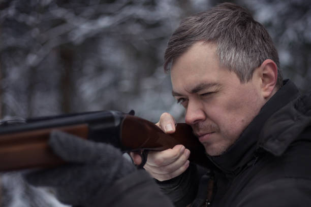 istock The hunter with a gun is in the winter forest 681011794