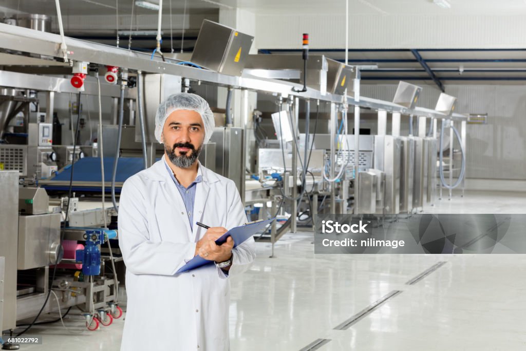 Food Industry Man working at a food factory. Food And Drink Industry Stock Photo