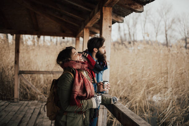 Exhausted hikers taking a break in the cottage with a hot drink