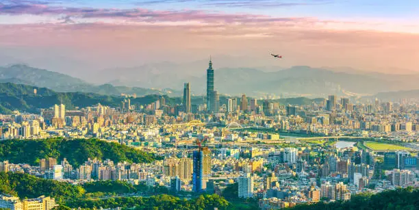 Beautiful view of an airplane flying over Taipei city at sunset