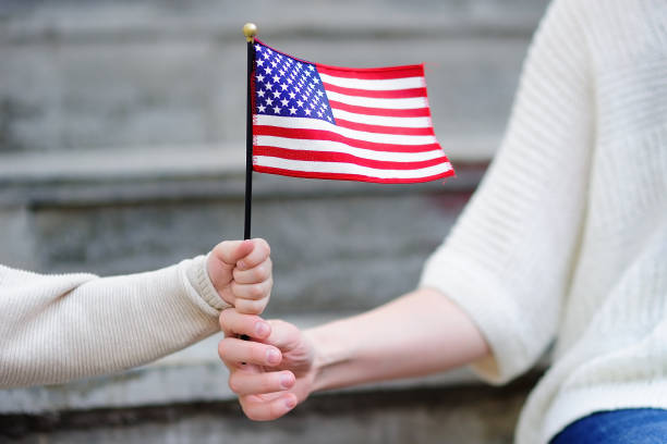 jeune femme et petit enfant tenant le drapeau américain - usa child flag the americas photos et images de collection