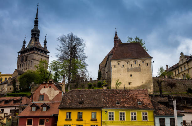 bright coloured traditional architecture and clock tower in sighisoara old town, transylvania, romania - vlad vi imagens e fotografias de stock