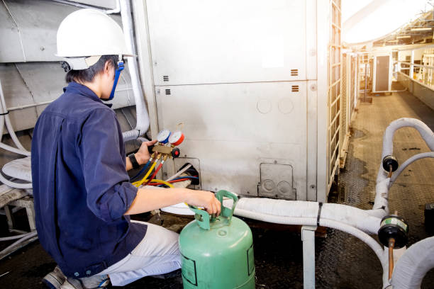 técnico es control de acondicionador de aire - air conditioner electricity repairing furnace fotografías e imágenes de stock