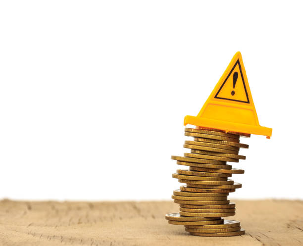 istock Financial risk. Coins falling and Warning label on whitebackground 681069898