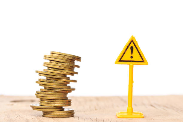 istock Financial risk. Coins falling and Warning label on whitebackground 681069938