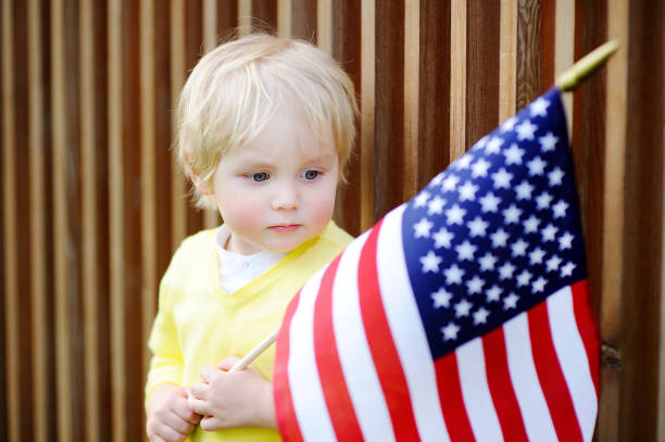 istock Cute toddler boy holding american flag 681080184