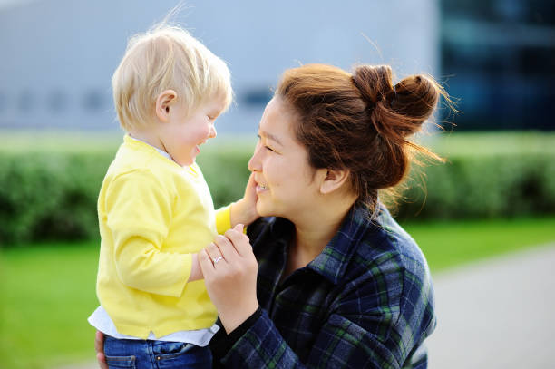 Young loving asian woman with cute caucasian toddler boy Young loving asian woman with cute caucasian toddler boy. Babysitting concept asian nanny stock pictures, royalty-free photos & images