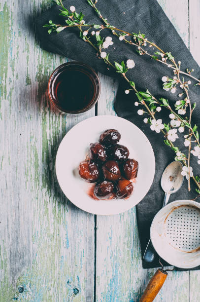 Pickled plum on a white plate over old wooden table