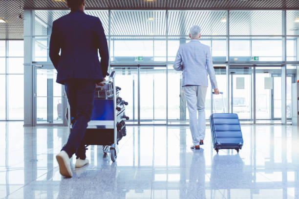 istock People with luggage walking to exit gates in airport 681161298