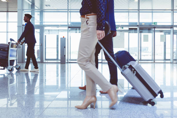 istock People walking with suitcases in airport terminal 681163488