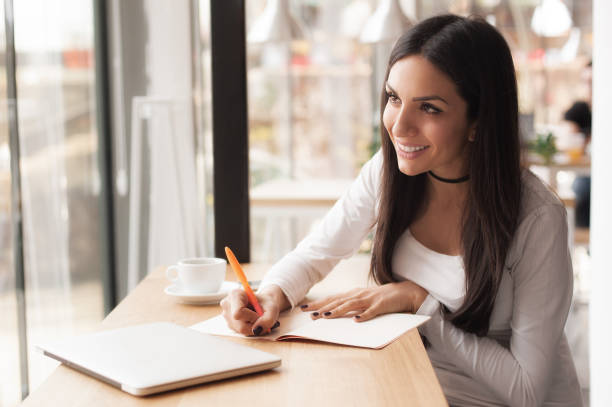 istock Young woman writing in her notebook and drinking morning coffee 681170234