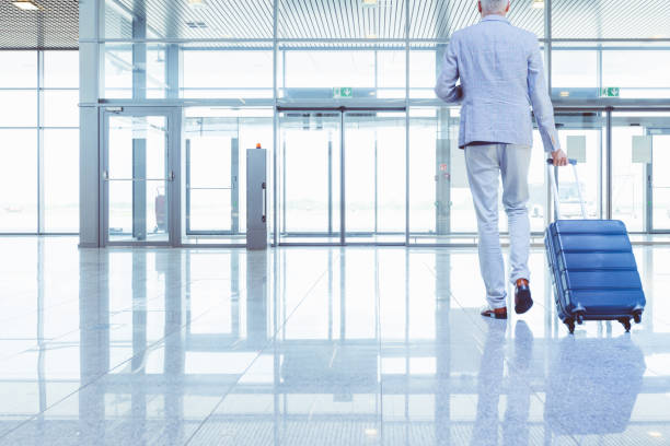 istock Businessman walking with suitcase in airport 681170478