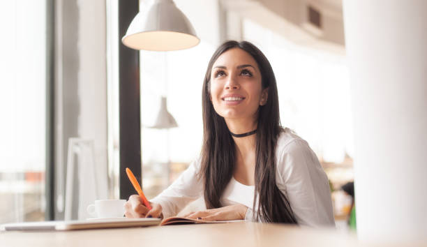 istock Young woman writing in her notebook and drinking morning coffee 681170620
