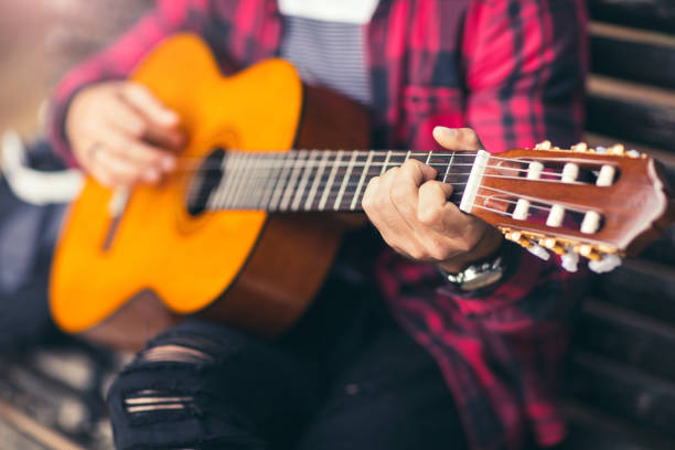 istock Man playing acoustic guitar on a park bench 681201060