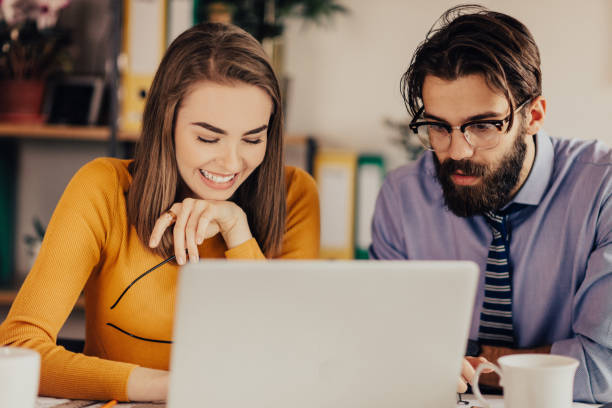 istock Smiling assistant working on a laptop with her superior 681203600
