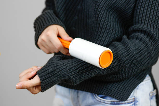 istock Girl cleans clothes sticky roller. Close up. Isolated 681212562