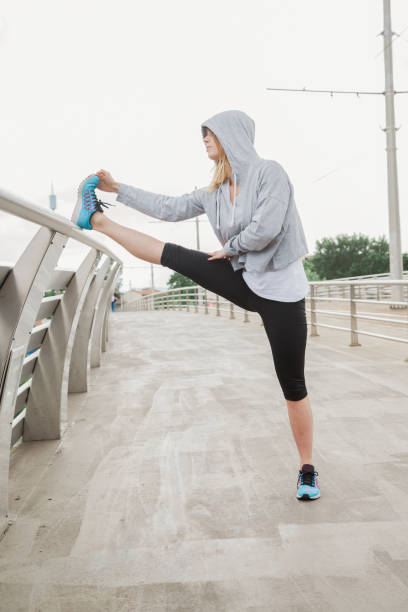 istock Beautiful young woman does stretching on bridge after hard workout in a spring afternoon 681214526