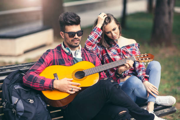istock Young couple playing guitar at the park 681236042
