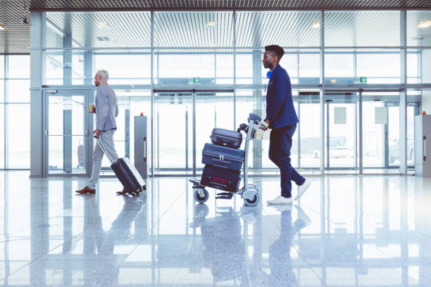 passeggeri con bagagli al terminal dell'aeroporto - baggage wagon foto e immagini stock