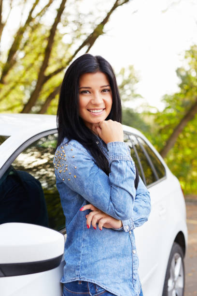 istock Woman standing and leaning on car door 681257402