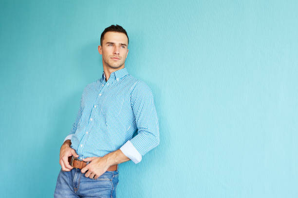 istock Handsome man leaning against a turquoise wall 681258142