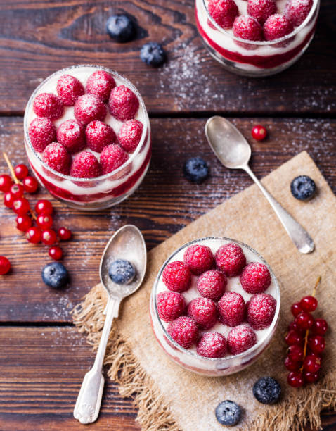 Raspberry dessert, cheesecake, trifle, mouse in a glass on a wooden background. Top view