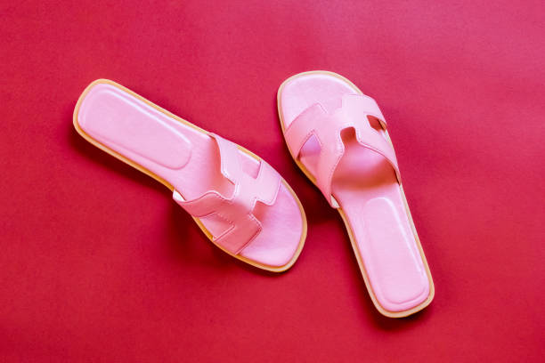 istock Pink sandals on Red background top view with copy space 681286076