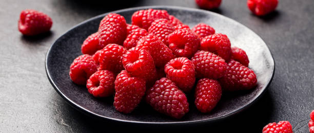 istock Fresh raspberries on a black bowl Slate background 681287136