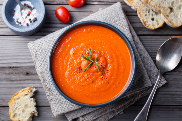 istock Tomato soup in a black bowl on wooden background. Top view. Copy space 681288690