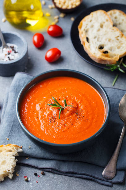 istock Tomato soup in a black bowl on grey stone background. 681295694