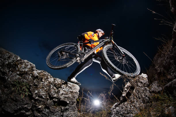 istock Athlete jumping across rocks with his bicycle 681297264