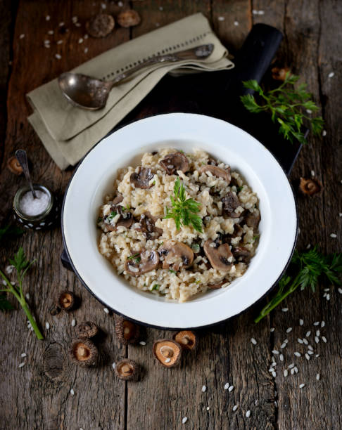 istock Risotto with mushrooms on an old wooden background. Rustic style. 681305194